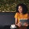 person sitting at table with tablet and coffee cup